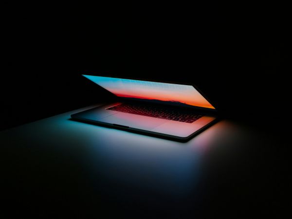 Photo of an opening laptop, glowing