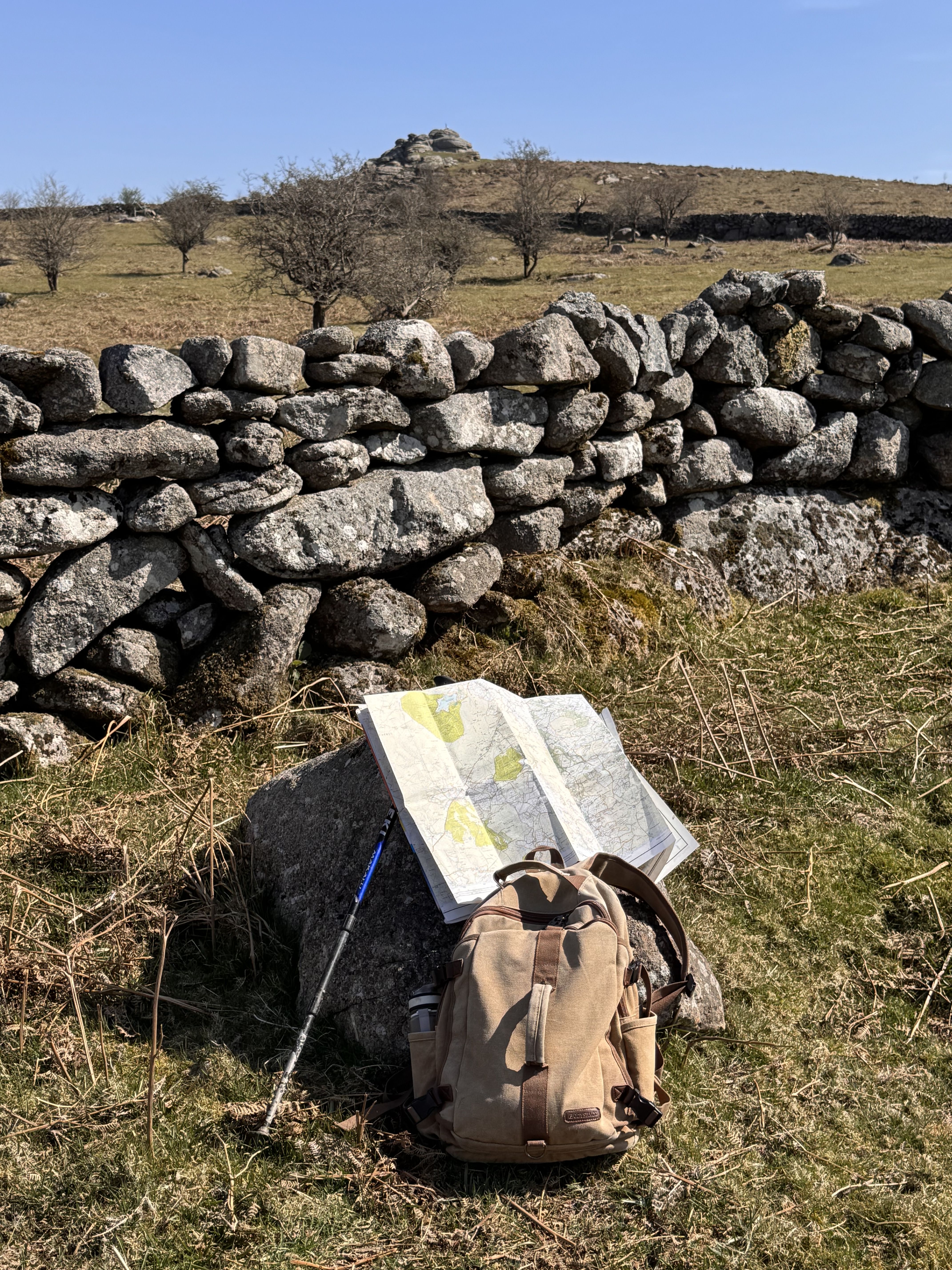 Photo of a landscape with a hiking backpack and map