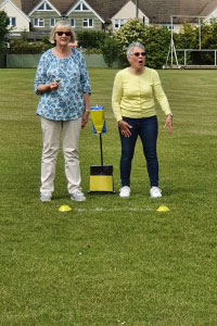 Two woman standing on a field playing a game 