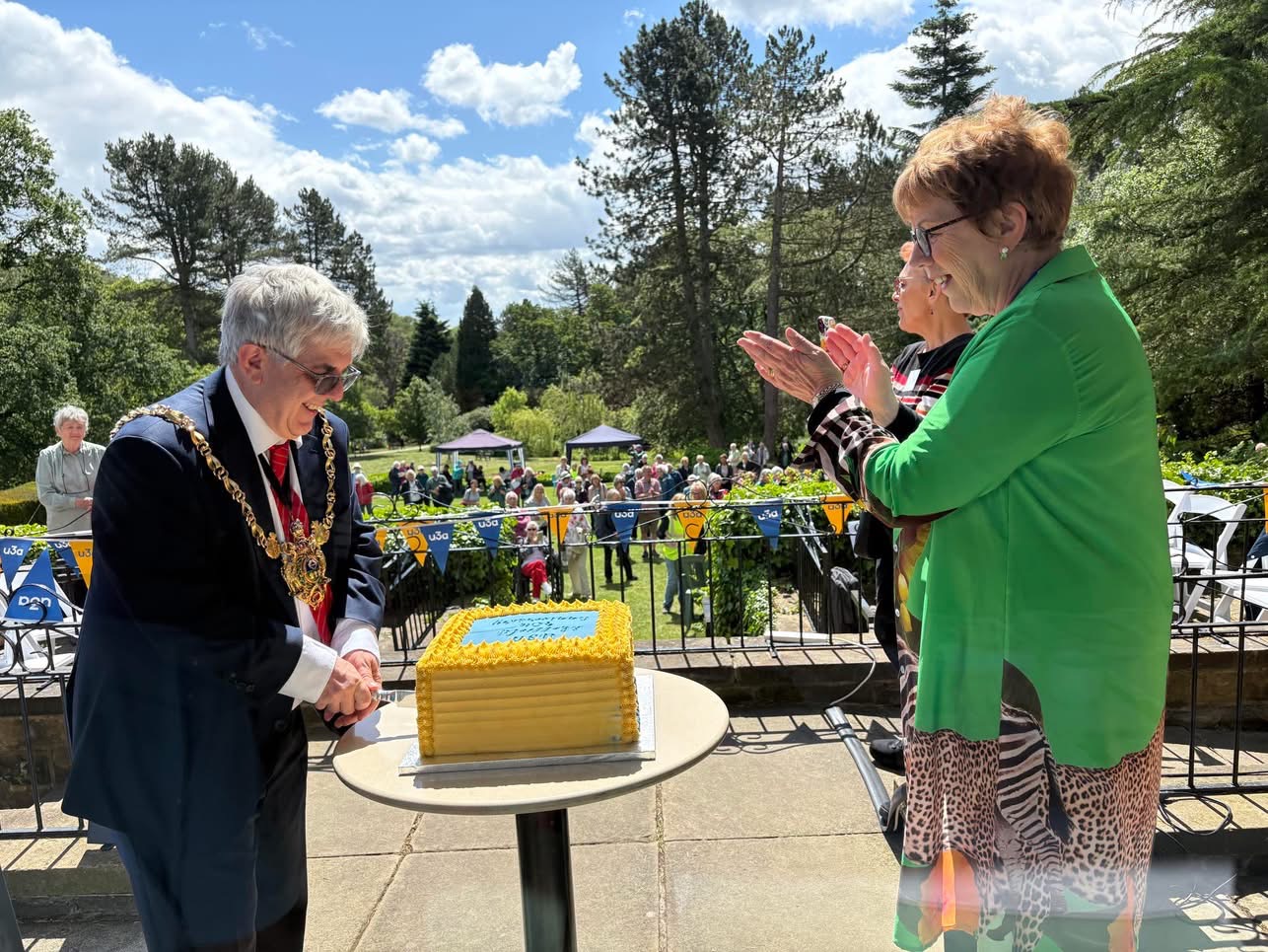 Mayor of Sheffield u3a cutting an anniversary cake for u3a with people clapping around him