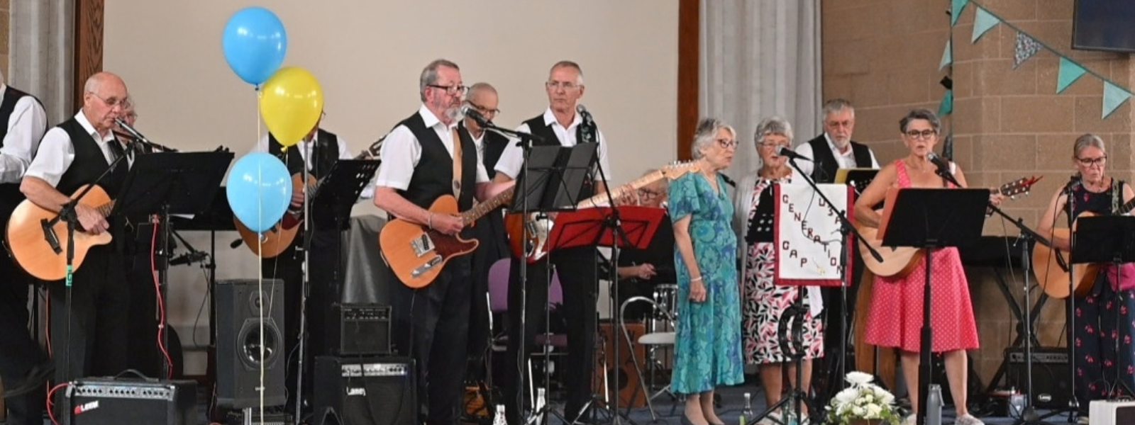 a group of people on stage singing and playing instruments
