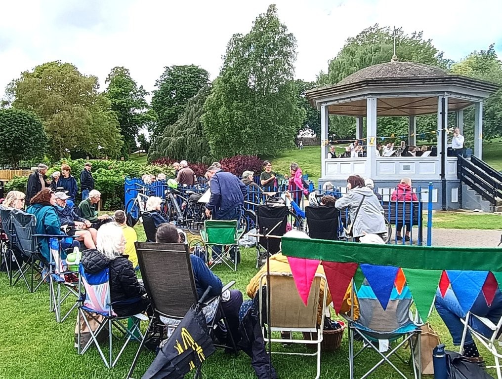 u3a members sitting around a gazebo listening to live music