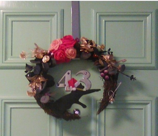 Photo of a Christmas wreath featuring a black cat