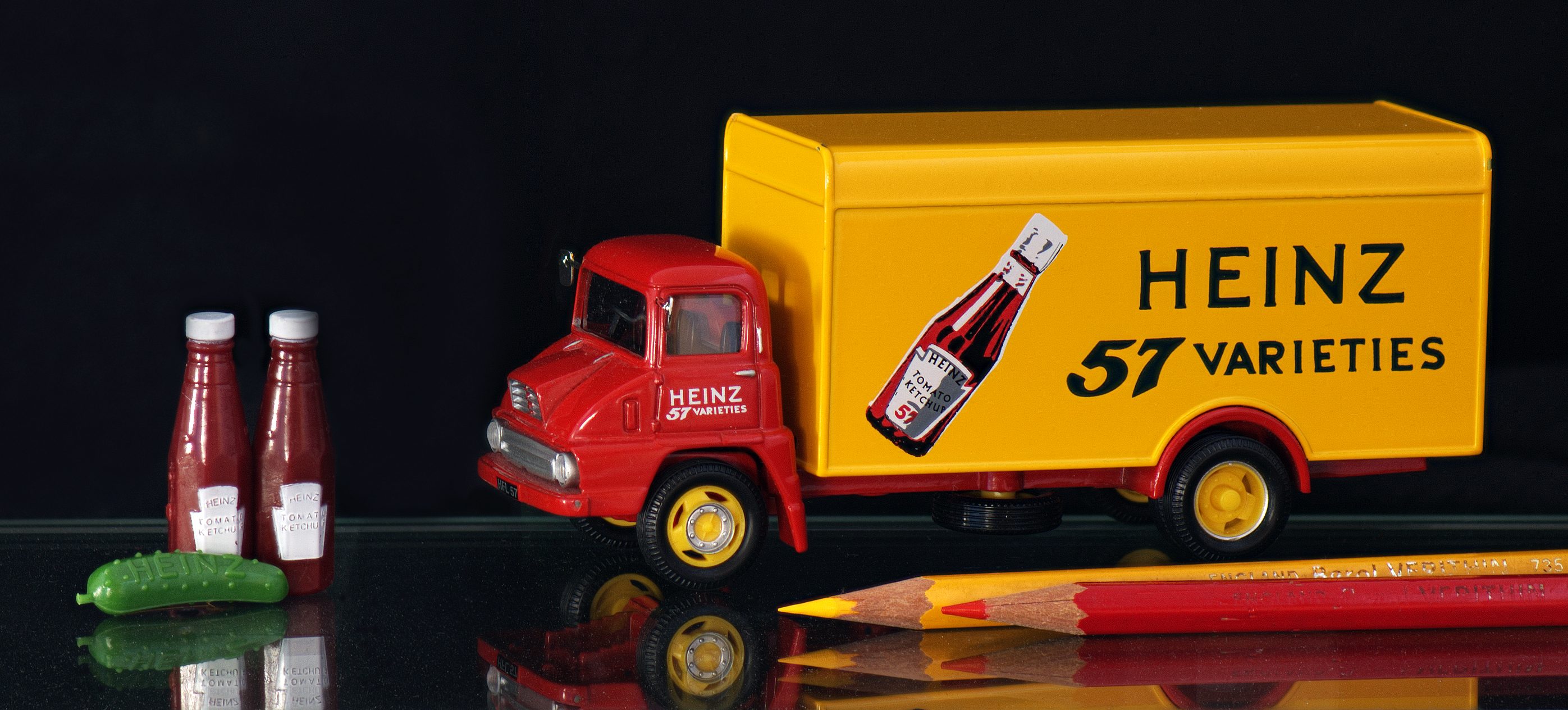 A toy truck, small toys and pencils