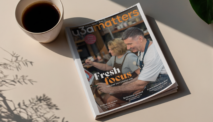 u3a matters magazine on a wooden table surrounded by plants