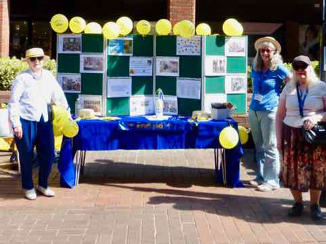 group of people in front of a u3a stall