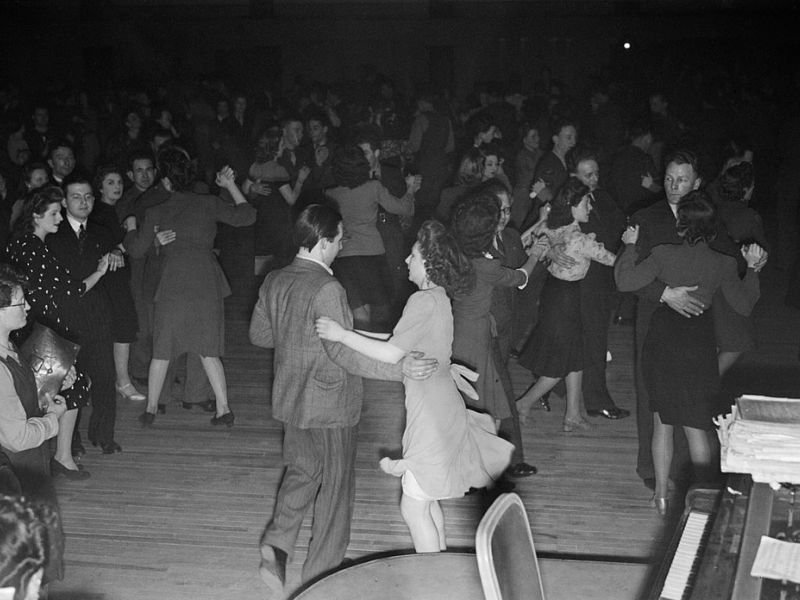 black and white photo of an english dancehall with people dancing