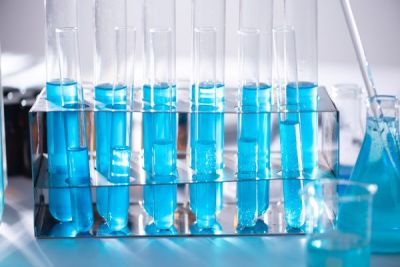 6 large and 6 small test tubes in a carrier with blue liquid in all of them