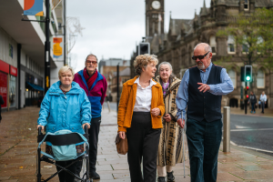 A group of older friends walking down a high street