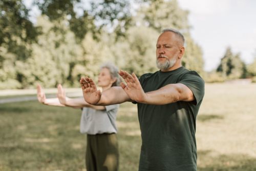A man and woman practice Tai chi outdoors