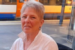 A woman in a white shirt sitting down