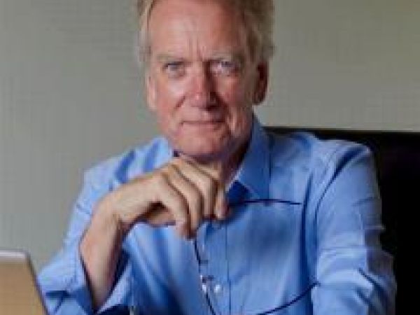 man in blue shirt sitting at laptop