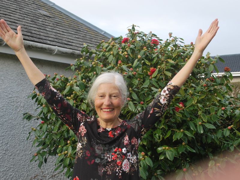 woman smiling with arms in the air