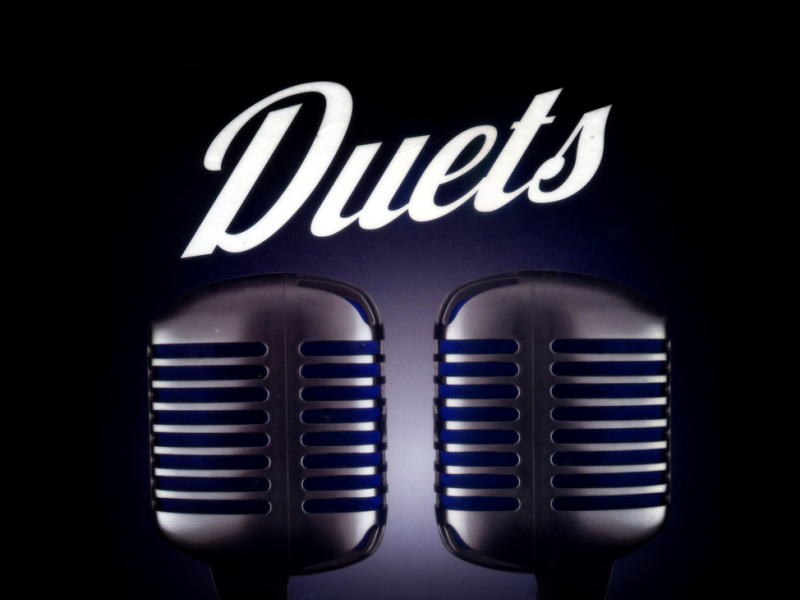 graphic showing two microphones with the word 'duets'