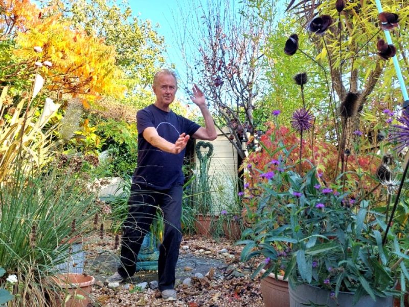 Photo of Paul engaged in Qigong in a garden