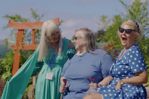 three women smile and laugh in front of a japanese style garden