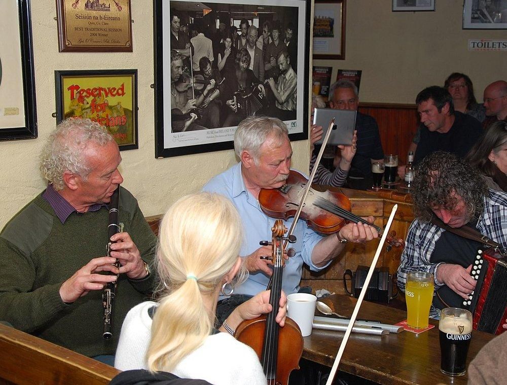 Group of Irish musicians performing in a pub. Author: Gérald Tapp, Wikipedia Commons