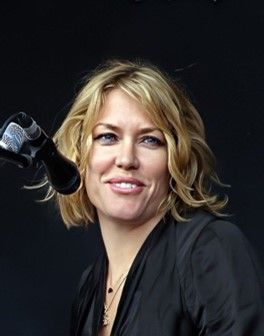 blonde lady by microphone in black top
