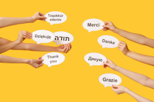 eight hands holding speech bubbles with different languages against a yellow background