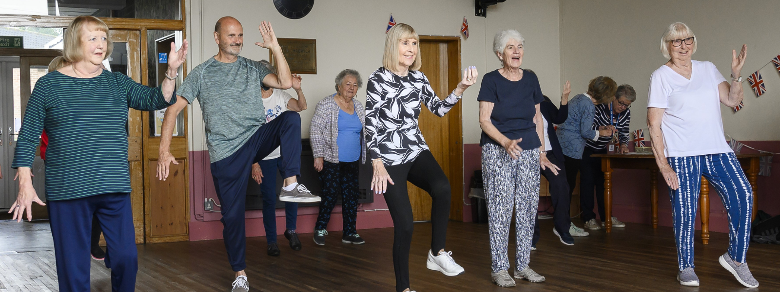 A group of men and women doing tai chi in a u3a group