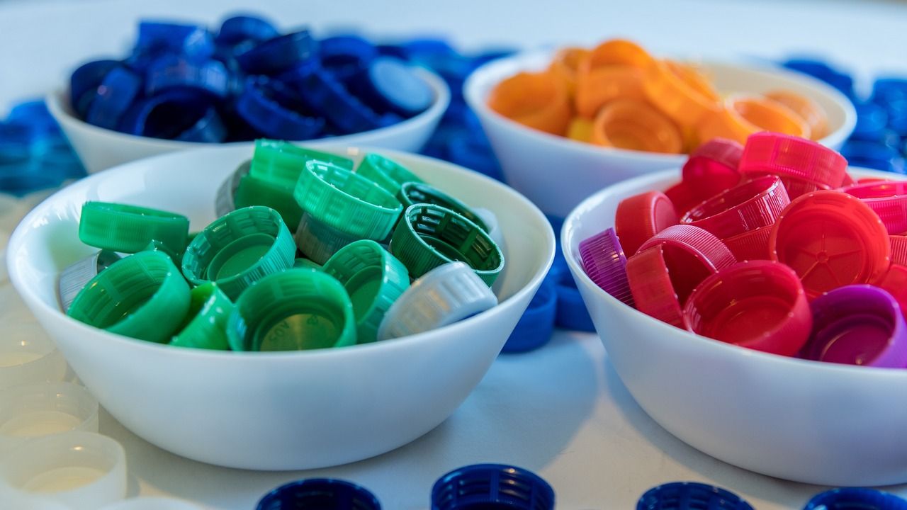 Photo of coloured plastic lids sorted into bowls